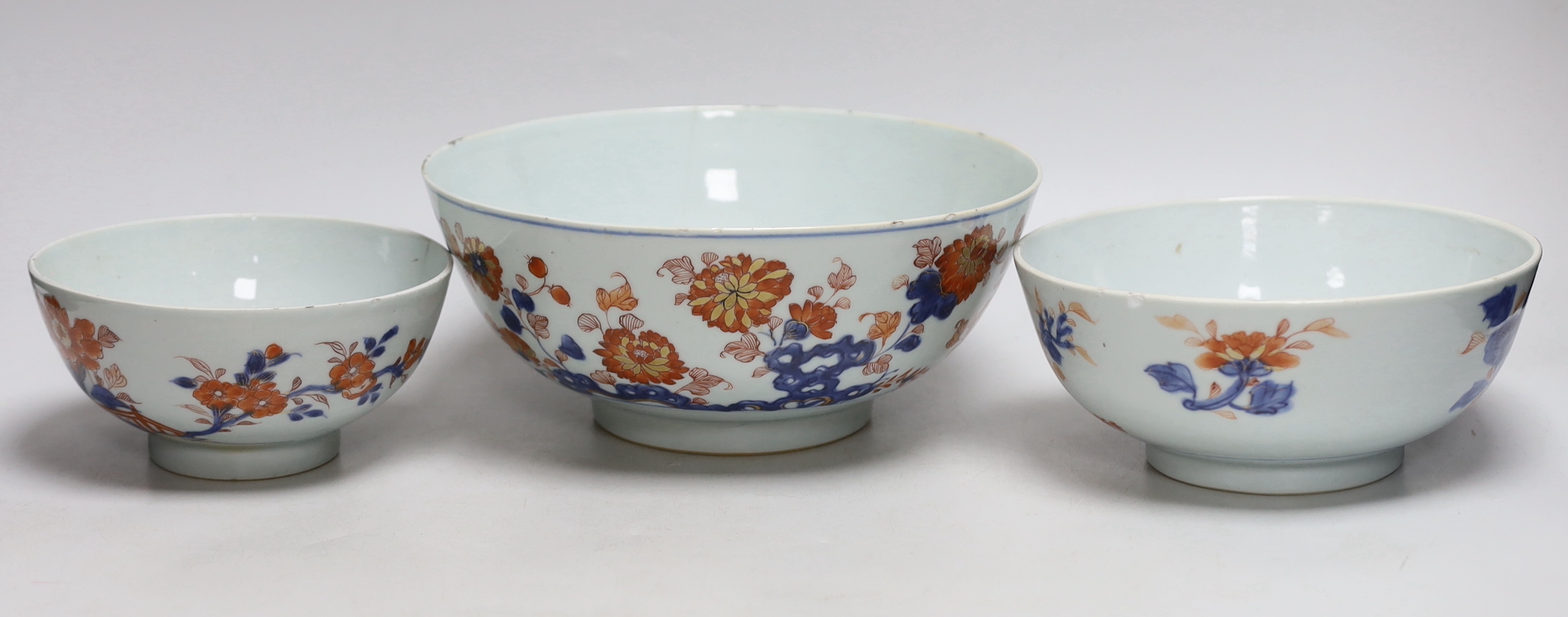 A graduated set of three Chinese Imari bowls, Qianlong period, hand painted with flowers, the largest 23cm in diameter